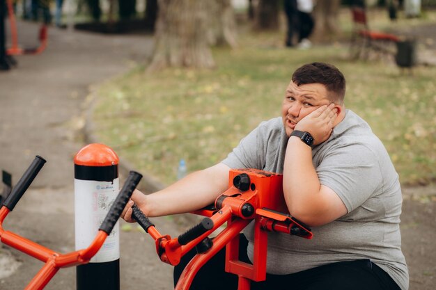 ein fetter Mann treibt Sport im Park