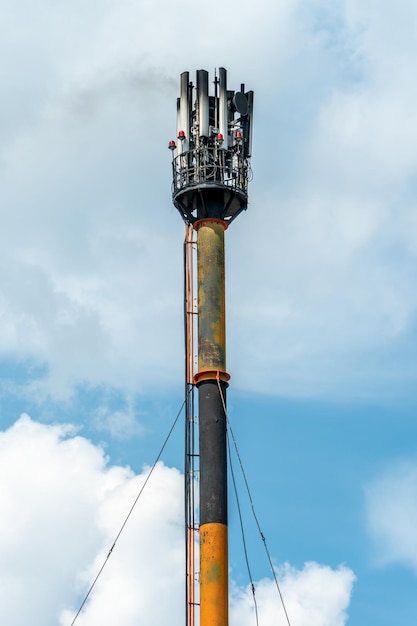 Ein Feuer an einer GSM-Antenne auf einem hohen Turm Vor dem Hintergrund des blauen Himmels ein Sender zum Senden eines 5g-Signals Gesundheitsgefährdende Strahlenbelastung der Umwelt durch Mobilfunkmasten