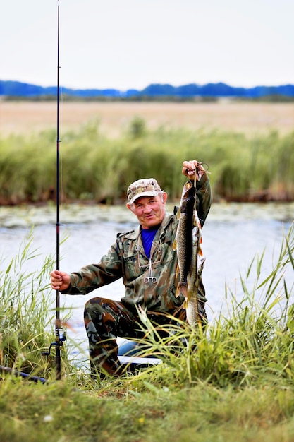 Ein Fischer mit Angelrute zeigt Fischfang