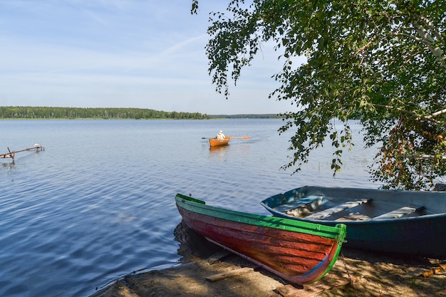 Ein Fischer segelt auf einem Boot auf dem See zum Ufer