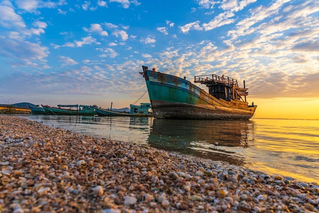 Ein Fischerboot, das bei einem wunderschönen Sonnenaufgang am Ufer festgemacht ist