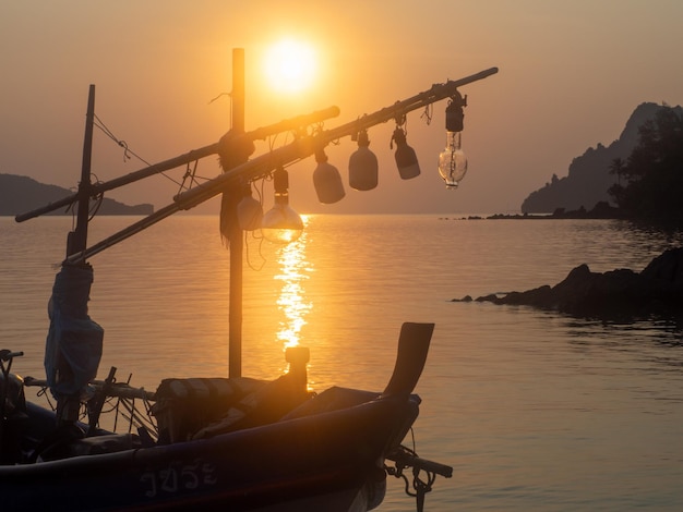 Ein Fischerboot, das bei Sonnenuntergang an der Küste stationiert ist