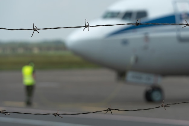 Ein Flugzeug auf dem Territorium des Flughafens vor dem Hintergrund von Stacheldraht Geschlossenes Territorium eines privaten Flugplatzes Notlandung des Flugzeugs Das Flugzeug befindet sich auf der Landebahn