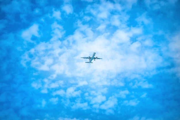 Ein Flugzeug fliegt am blauen Himmel mit weißen Wolken
