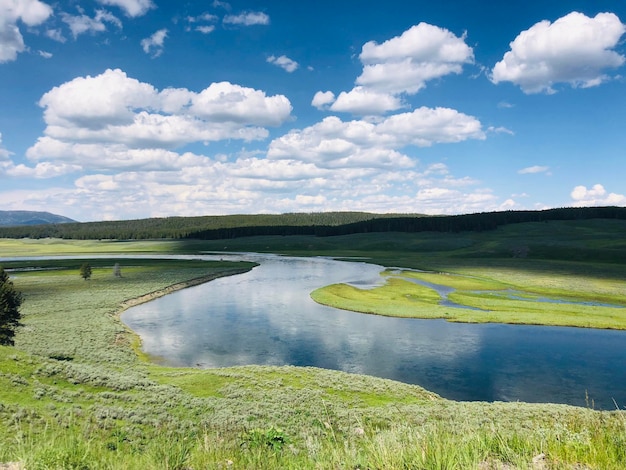 Ein Fluss fließt in ein Tal, das von Hügeln und Bäumen umgeben ist