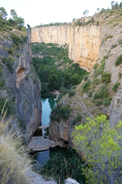 Ein Fluss in den Bergen mit einer Brücke im Hintergrund