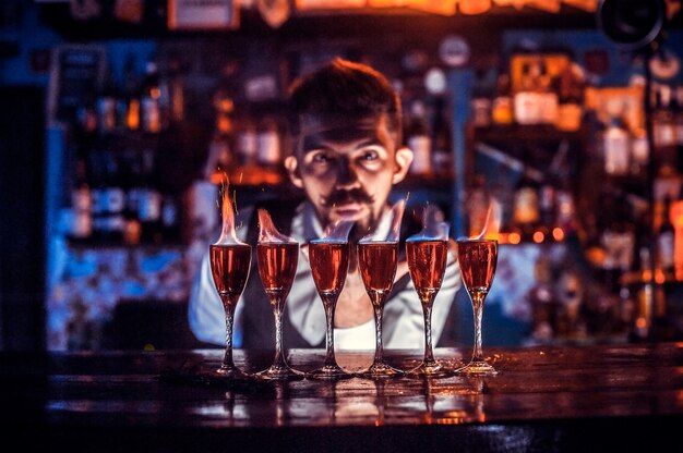 Ein fokussierter Mixologe demonstriert den Prozess der Herstellung eines Cocktails in Cocktailbars