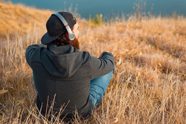 Ein Foto eines Mannes, der die Musik auf dem Feld von hinten hört