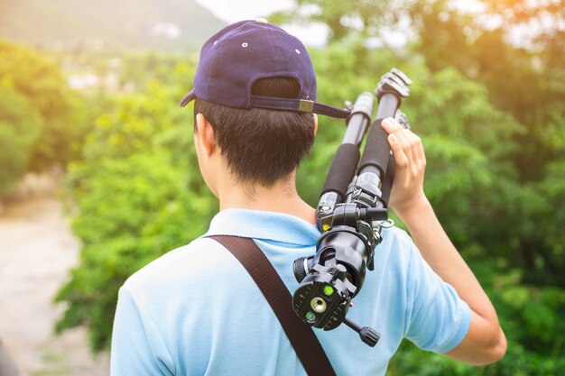 Ein Fotograf oder ein Reisender mit einem Kamerastativ in der Natur für Hintergrund.