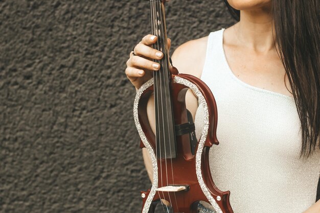 Ein Fragment einer elektrischen Geige eine Geige in den Händen eines Musikermädchens