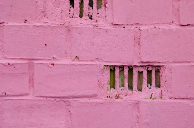 Ein Fragment einer rosa gestrichenen Backsteinmauer.