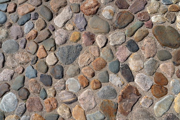 ein Fragment einer Stadtmauer aus Naturstein verschiedener Farben und Texturen