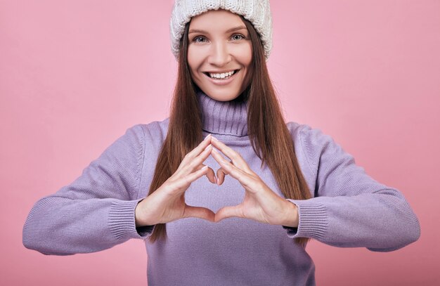 Foto ein freundliches, charmantes mädchen in weißer strickmütze und einem lila pullover