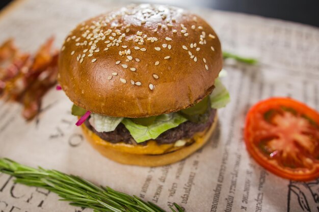 Ein frischer leckerer Burger mit geschnittenen Tomaten und Speck in einem Café