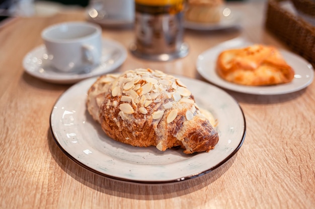Ein frisches großes Croissant auf einem schönen Teller in einem Café oder Restaurant Nahaufnahme eines Croissants