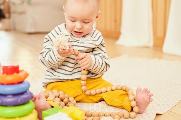 Ein fröhlicher, gesunder, hübscher kleiner Junge, der auf dem Holzboden des Kinderzimmers kriecht