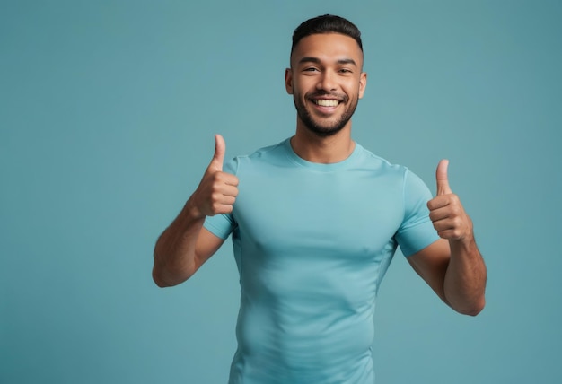 Ein fröhlicher Mann in einem blaufarbenen T-Shirt, der einen doppelten Daumen nach oben wirft und Fröhlichkeit ausstrahlt