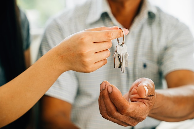 Ein fröhliches Ehepaar feiert das neue Hausbesitz und zeigt die Schlüssel zu ihrem Haus