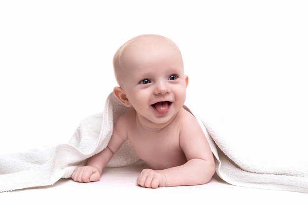 Ein fröhliches Neugeborenes lacht auf einem weißen Hintergrund, der unter einem Handtuch hervorschaut