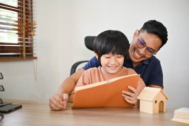 Ein fürsorglicher asiatischer Vater bringt seinem Sohn bei, ein Kinderbuch zu lesen