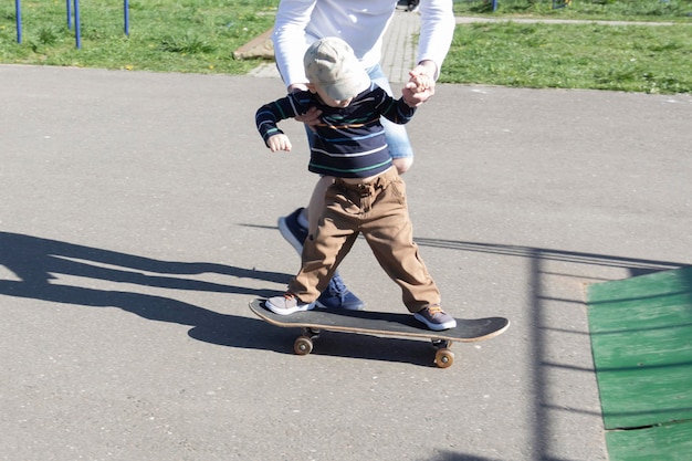 Ein fürsorglicher und liebevoller Vater bringt seinem dreijährigen Sohn das Skateboarden bei