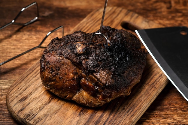Ein ganzes gebackenes Stück Fleisch Ein Stück Schweinefleisch in Gewürzen, das im Ofen auf einem Holzbrett gekocht wird