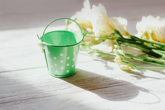 Ein gartenkübel auf einem hintergrund aus blumen und holzbrettern