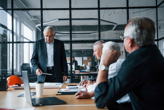 Ein gealtertes Team älterer Geschäftsmannarchitekten trifft sich im Büro.