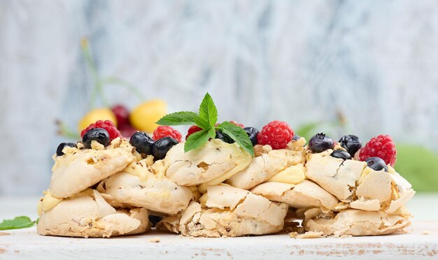 Ein gebackener Kuchen aus geschlagenem Hühnerprotein und Sahne, dekoriert mit frischen Beeren Dessert Pavlova