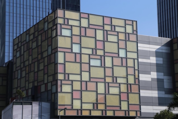Ein Gebäude aus großen Glasblöcken mit mehrfarbigen Pastellquadraten. Die Fassade ist im architektonischen Stil der modernen Architektur