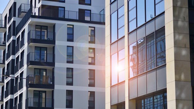 ein Gebäude mit einem Balkon und der Sonne, die auf die Fenster scheint.