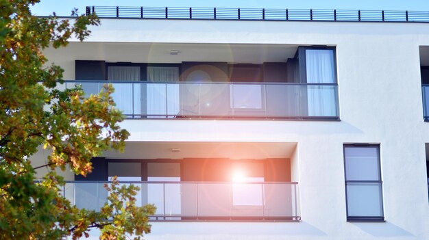 Ein Gebäude mit einem Balkon und einem Baum davor