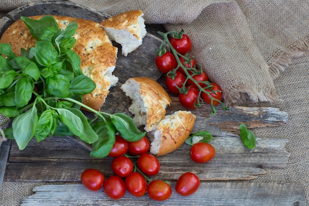 Ein gebrochenes Brot, Tomaten und Basilikum hautnah