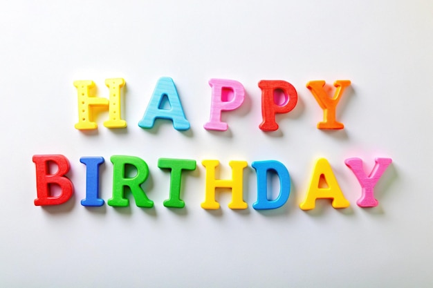 ein Geburtstagskuchen mit Kerzen, die "Glücklicher Geburtstag" sagen