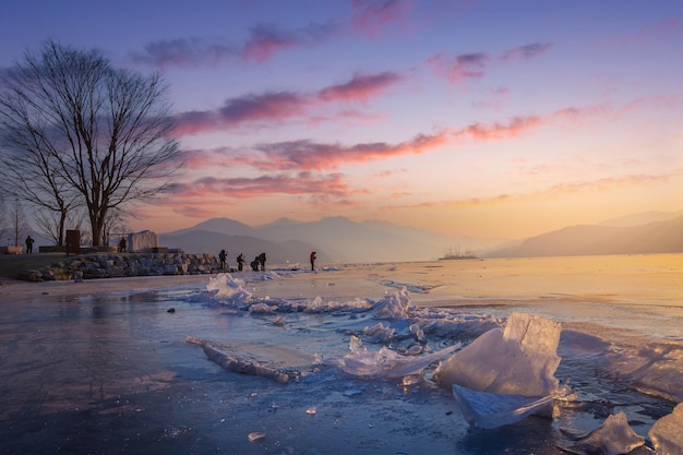 Ein gefrorener See in Südkorea im Winter bei Sonnenaufgang und große Bäume im Hintergrund in Dumulmeori Yangpyeong Südkorea