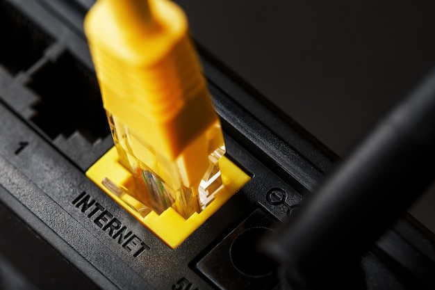 Ein gelbes Patchkabel wird in den WLAN-Anschluss des Routers eingesteckt, um auf das Internet zuzugreifen