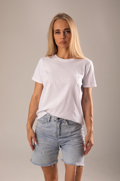 Ein gelegentlicher Sommer-Mode-Schuss einer jungen Frau in einem weißen T-Shirt und Jeans-Shorts