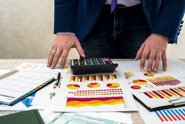 Ein Geschäftsmann analysiert Einnahmen und Grafiken im Büro