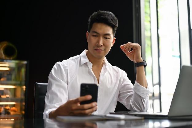 Ein Geschäftsmann benutzt sein Smartphone in einem Café