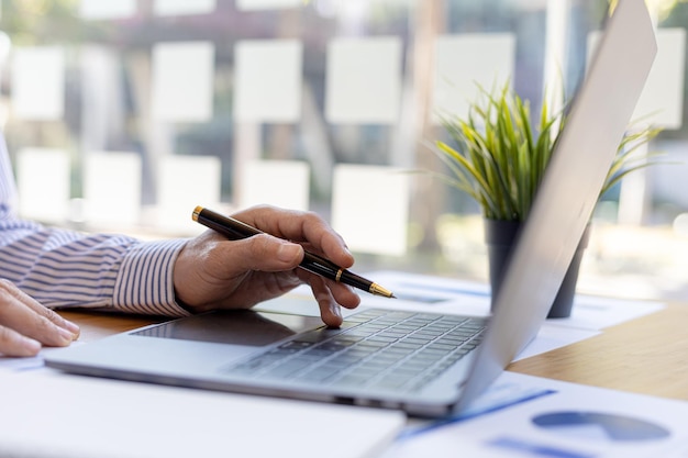 Ein Geschäftsmann, der in einem privaten Raum arbeitet, er tippt auf einer Laptop-Tastatur, er benutzt einen Messenger, um mit einem Partner zu chatten. Konzept der Verwendung von Technologie in der Kommunikation.