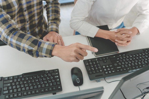 Ein Geschäftsmann diskutiert mit einem Kollegen, während er im Büro sitzt