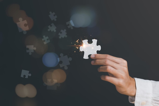 Ein Geschäftsmann hält ein Puzzleteil, um eine geschäftliche Lösung zu finden