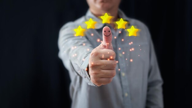 Foto ein geschäftsmann hebt den daumen auf das glückliche smiley-icon und fünf sterne, um zufriedenheit in der dienstleistung zu geben. sehr beeindruckt kundenservice und zufriedenheitskonzept