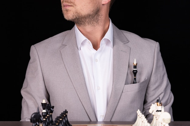 Ein Geschäftsmann in einem Business-Anzug mit einer Schachfigur in der Tasche