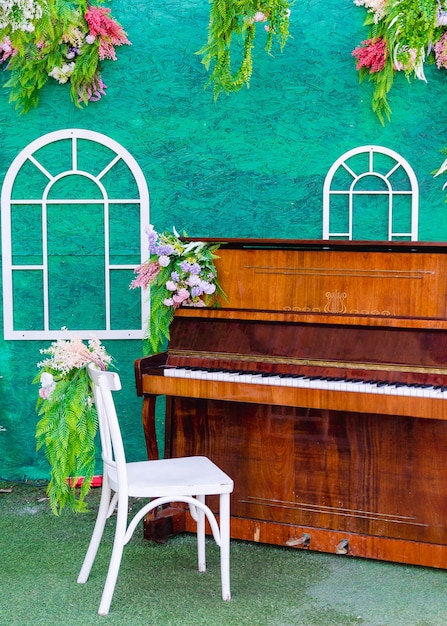Ein geschmückter Bereich zum Fotografieren und Videos machen mit einem Klavier und einem mit Blumen geschmückten weißen Stuhl
