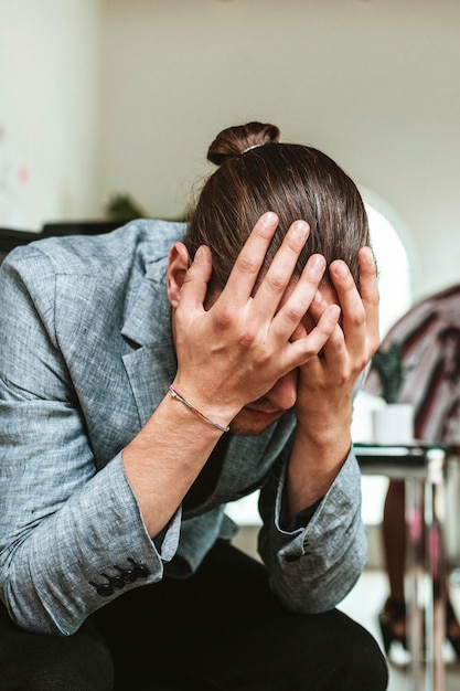 Ein gestresster Geschäftsmann, der auf einem Stuhl in einem Büro sitzt