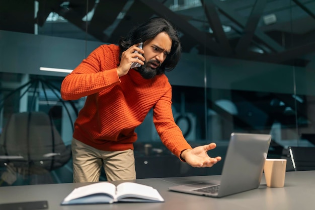 Ein gestresster indischer Manager kämpft am Telefon mit seinem Assistenten