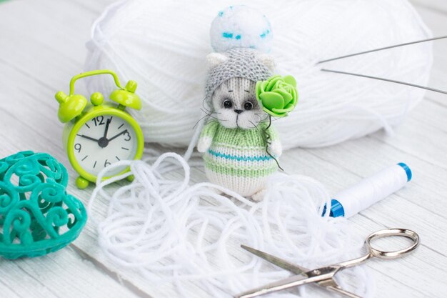 Ein gestricktes Kätzchen mit Stricknadeln farbigen Fadenknäuel in einem Korb Kreativ-Workshop zum Thema Handarbeit Handarbeit