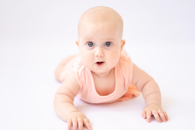 Ein gesundes glückliches süßes Baby liegt auf dem Bauch und schaut in die Kamera