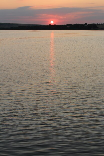 Ein Gewässer mit einem Sonnenuntergang dahinter